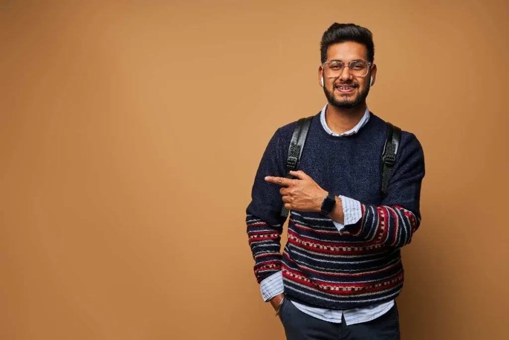 Smiling student with a backpack pointing to the side