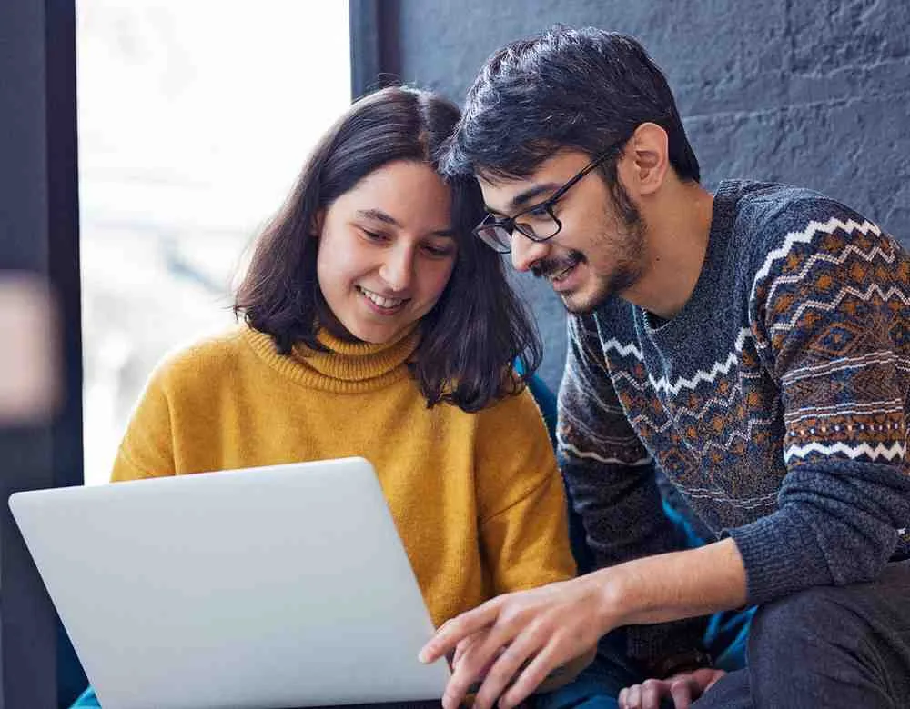 Two colleagues looking at a laptop together