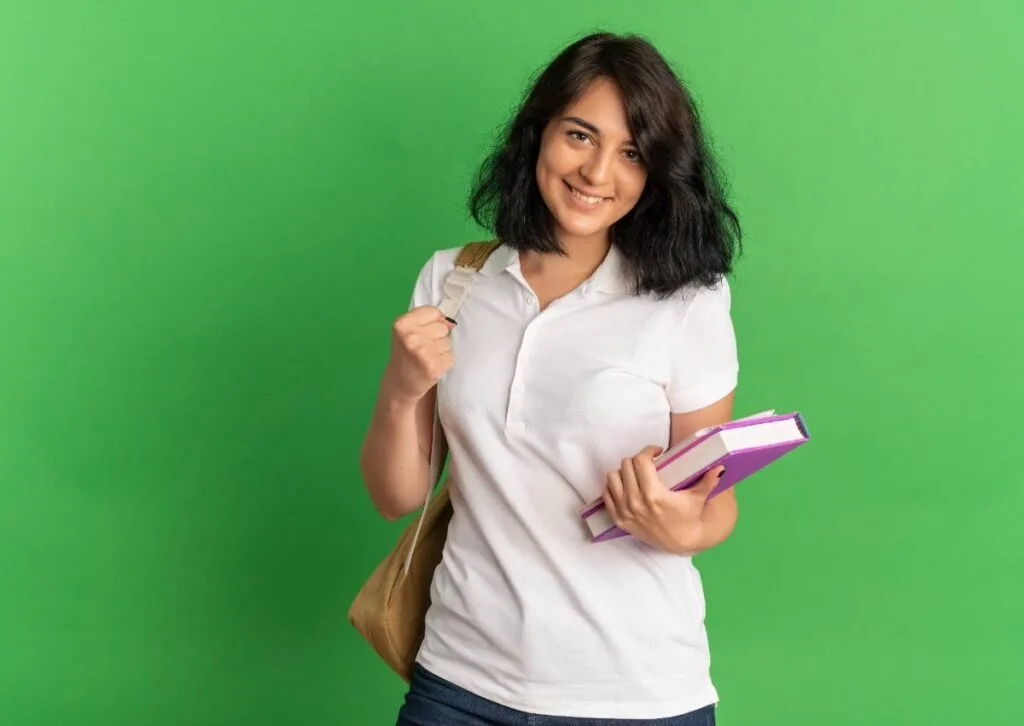 Student wearing a backpack and holding books